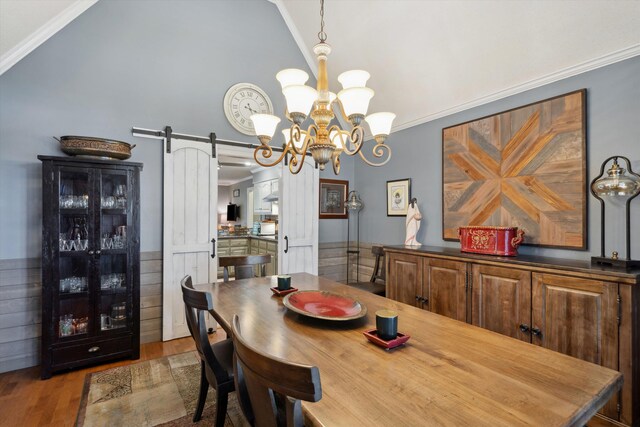 8792 E Carrollwood Ln E, Memphis, TN 38016 - dining space with a barn door, lofted ceiling, ornamental molding, wood finished floors, and a chandelier