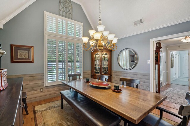 8792 E Carrollwood Ln E, Memphis, TN 38016 - dining space with wood finished floors, a chandelier, healthy amount of natural light, a wainscoted wall, and high vaulted ceiling