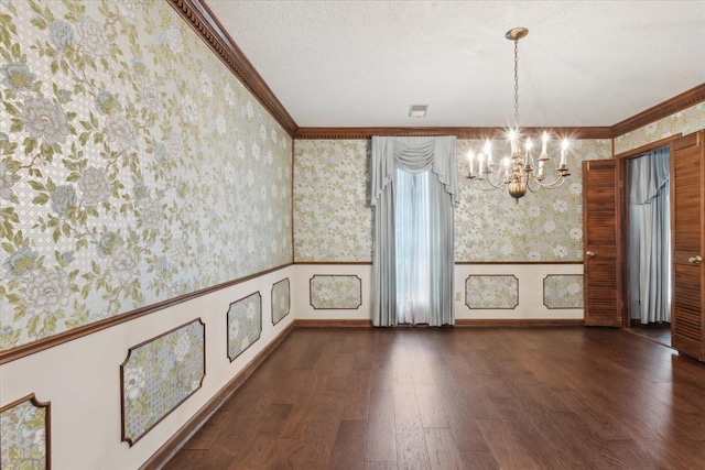 unfurnished dining area featuring wallpapered walls, a chandelier, wood finished floors, ornamental molding, and wainscoting
