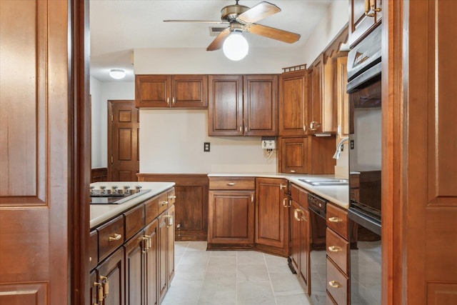 kitchen with light countertops, a ceiling fan, a sink, and brown cabinetry