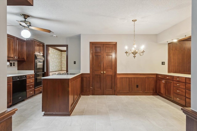 kitchen with black appliances, a peninsula, wainscoting, light countertops, and ceiling fan