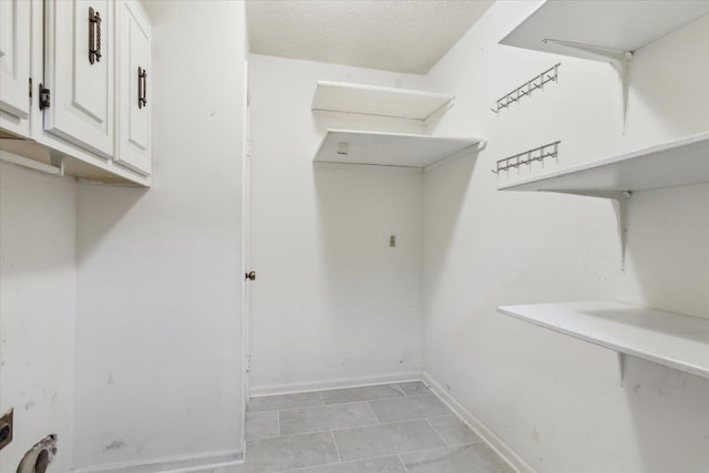 laundry area featuring cabinet space and baseboards