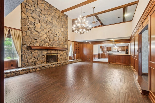 unfurnished living room featuring high vaulted ceiling, a chandelier, dark wood finished floors, beam ceiling, and a fireplace
