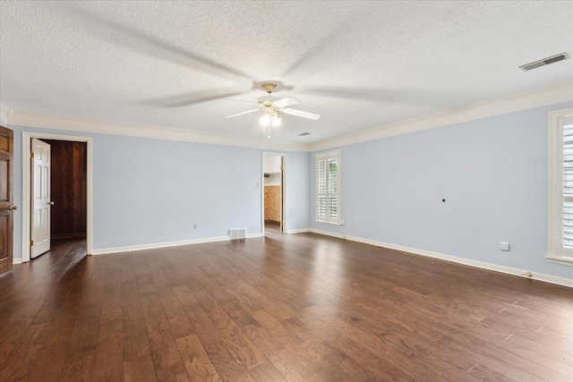 empty room featuring a ceiling fan, ornamental molding, dark wood-style flooring, a textured ceiling, and baseboards