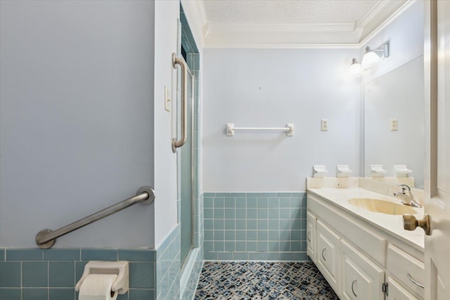 full bath with ornamental molding, tile walls, a shower with door, vanity, and tile patterned floors