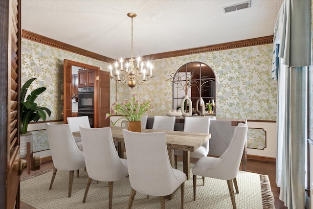 dining room with wallpapered walls, a chandelier, ornamental molding, and baseboards
