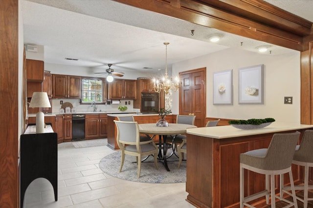 kitchen with oven, a sink, light countertops, a kitchen breakfast bar, and ceiling fan