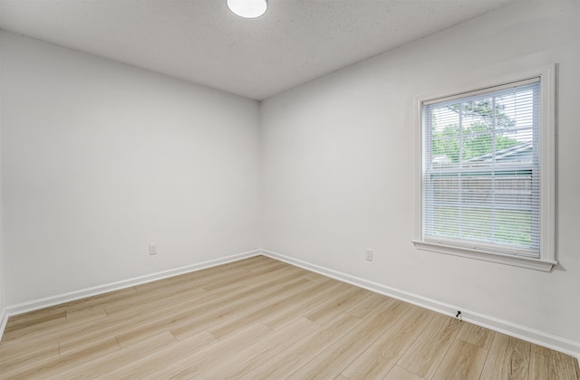 empty room featuring light wood-style floors and baseboards