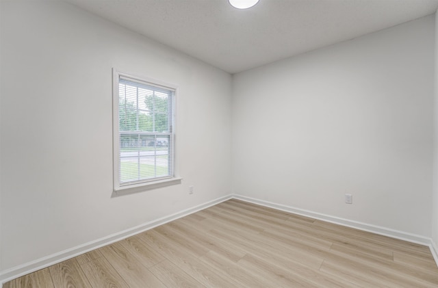 unfurnished room with light wood-style flooring and baseboards