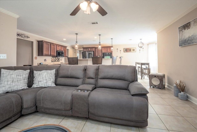 living room featuring ceiling fan, ornamental molding, light tile patterned flooring, and baseboards