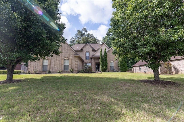 traditional home with brick siding and a front lawn