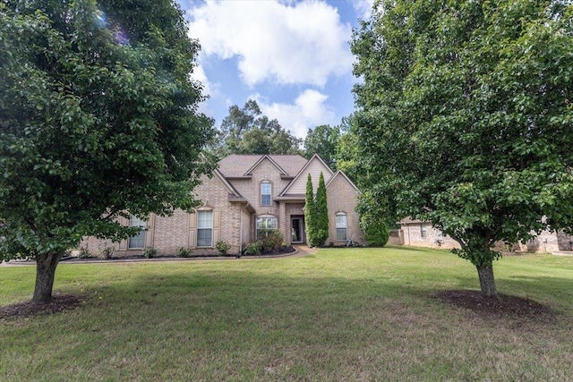 view of front of house with a front lawn and brick siding
