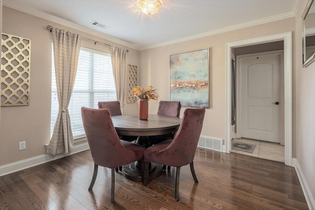 dining room with wood finished floors, baseboards, and crown molding