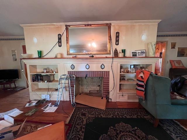 detailed view of crown molding, a fireplace, and wood finished floors