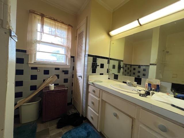 bathroom featuring crown molding, tile walls, vanity, tile patterned floors, and a wainscoted wall