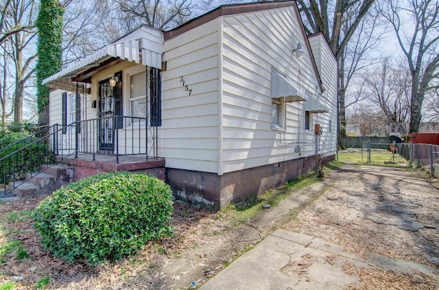 view of side of home featuring fence and crawl space