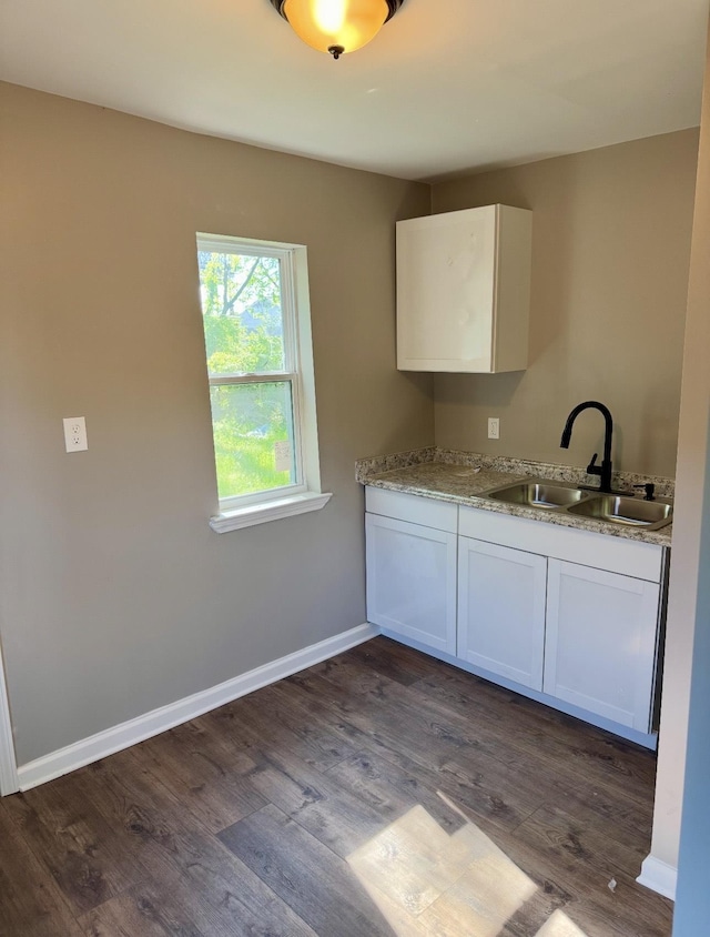 852 Marianna St, Memphis, TN 38114 - kitchen featuring a sink, white cabinetry, dark wood-style flooring, light stone countertops, and baseboards