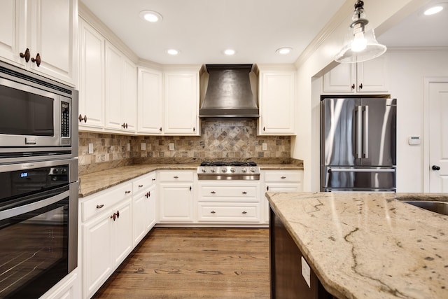 3850 Poplar Ave, Memphis, TN 38111 - kitchen with stainless steel appliances, premium range hood, dark wood-style floors, white cabinets, and light stone counters