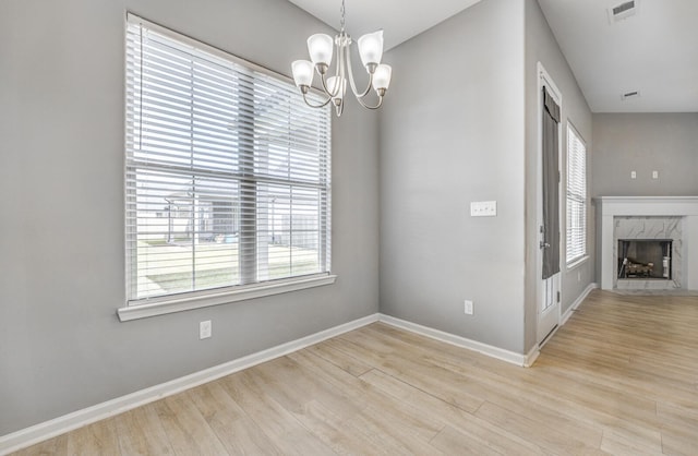 135 Briar Hollow Ln, Oakland, TN 38060 - unfurnished dining area with wood finished floors, a chandelier, baseboards, and a fireplace