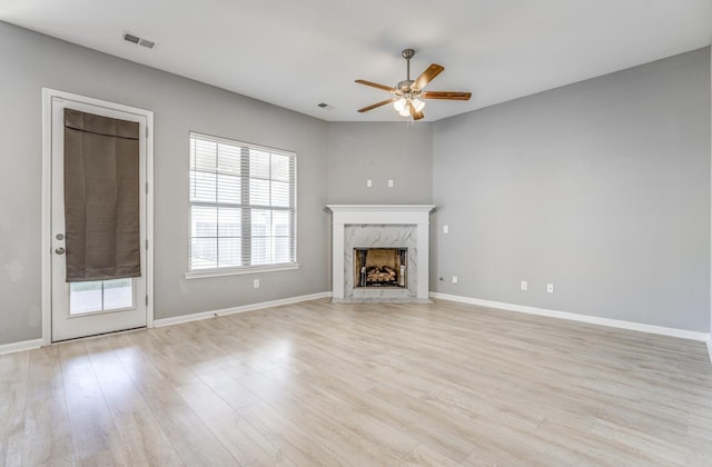 135 Briar Hollow Ln, Oakland, TN 38060 - unfurnished living room featuring ceiling fan, a high end fireplace, light wood-style floors, and baseboards