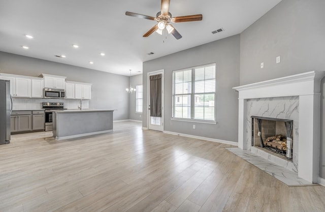 135 Briar Hollow Ln, Oakland, TN 38060 - unfurnished living room with ceiling fan, light wood finished floors, a fireplace, baseboards, and recessed lighting