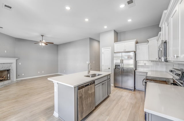 135 Briar Hollow Ln, Oakland, TN 38060 - kitchen with appliances with stainless steel finishes, a sink, ceiling fan, light wood-type flooring, and a high end fireplace
