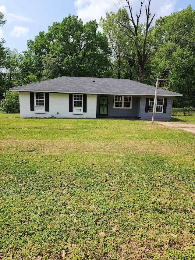 4785 Haleville Rd, Memphis, TN 38611 - ranch-style house featuring a front lawn and view of wooded area