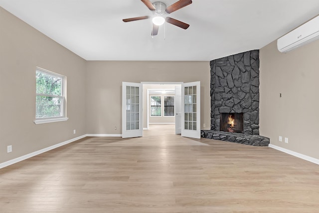 1793 Hayden Rd, Germantown, TN 38138 - unfurnished living room featuring a wall unit AC, a ceiling fan, baseboards, a fireplace, and light wood-style floors
