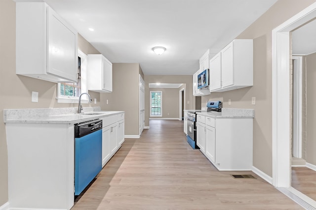 1793 Hayden Rd, Germantown, TN 38138 - kitchen featuring appliances with stainless steel finishes, a sink, light wood finished floors, baseboards, and white cabinetry