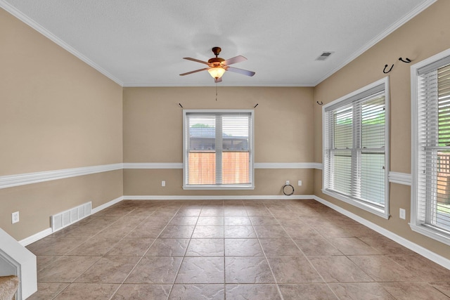 empty room featuring healthy amount of natural light, ceiling fan, ornamental molding, and baseboards
