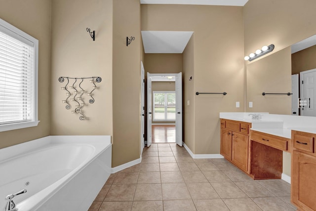 full bathroom with a bath, vanity, tile patterned flooring, and baseboards