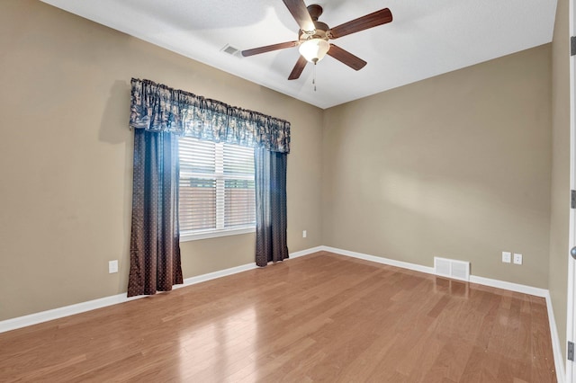 unfurnished room with a ceiling fan, light wood-style flooring, and baseboards