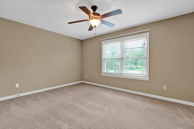 carpeted spare room featuring ceiling fan, baseboards, and a textured ceiling
