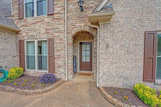 doorway to property featuring brick siding and stone siding