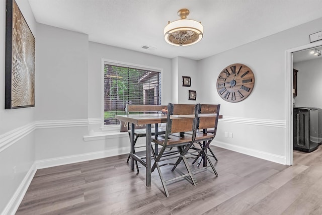 dining space featuring wood finished floors and baseboards