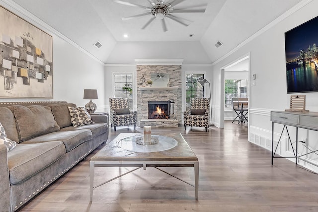 living room with a ceiling fan, healthy amount of natural light, wood finished floors, lofted ceiling, and a fireplace