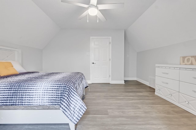 bedroom featuring vaulted ceiling, wood finished floors, baseboards, and ceiling fan