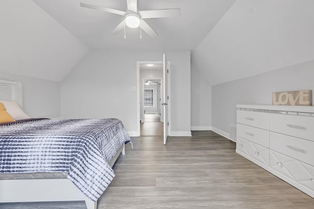 bedroom featuring vaulted ceiling, light wood finished floors, baseboards, and ceiling fan