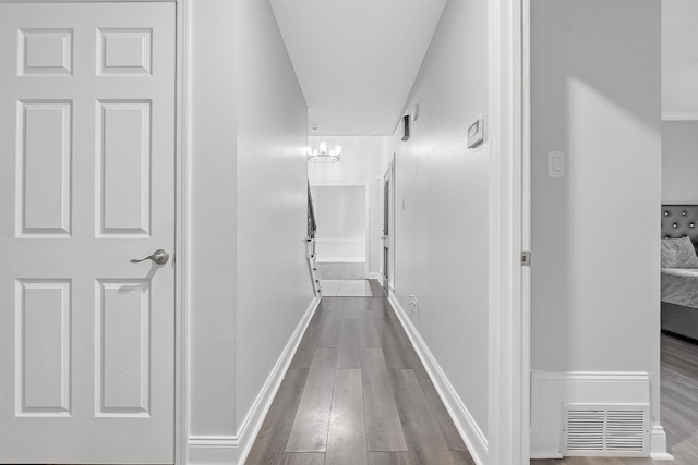 corridor featuring wood finished floors and baseboards