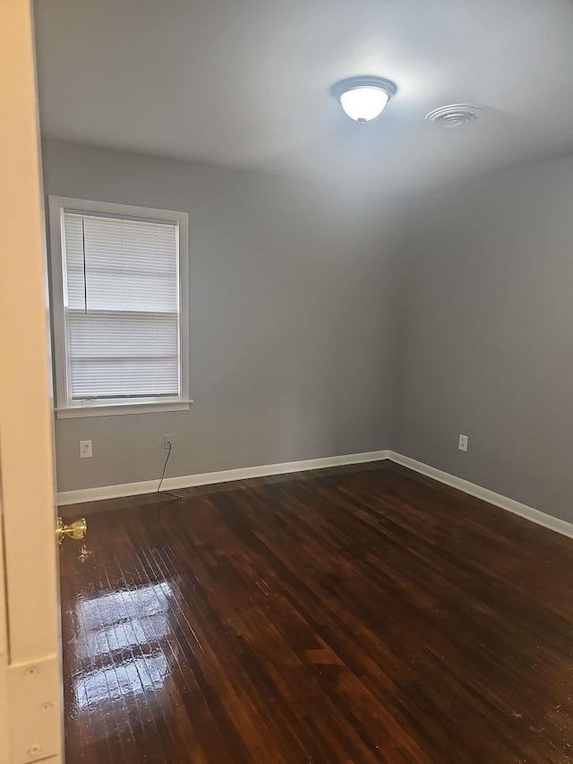 unfurnished room featuring wood-type flooring and baseboards