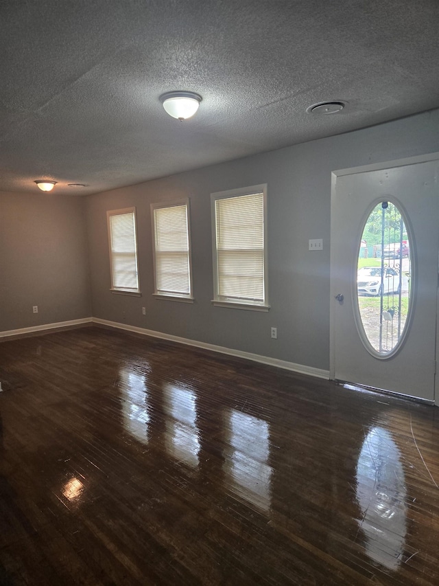 entryway with wood finished floors, a textured ceiling, and baseboards