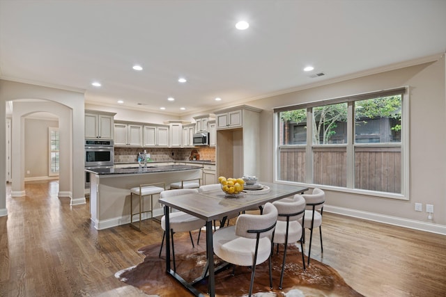 984 Russell Farms Rd, Collierville, TN 38017 - dining space with arched walkways, crown molding, wood finished floors, baseboards, and recessed lighting