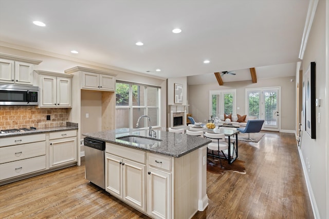 984 Russell Farms Rd, Collierville, TN 38017 - kitchen featuring appliances with stainless steel finishes, a sink, open floor plan, wood finished floors, and a fireplace