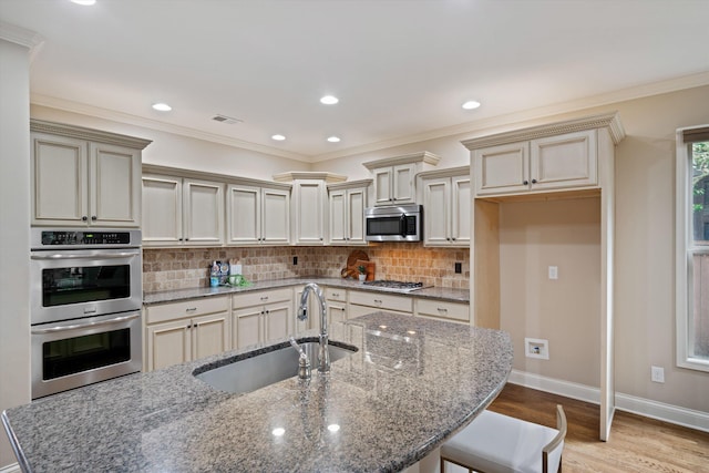 984 Russell Farms Rd, Collierville, TN 38017 - kitchen featuring a sink, stainless steel appliances, cream cabinets, backsplash, and light wood-style floors