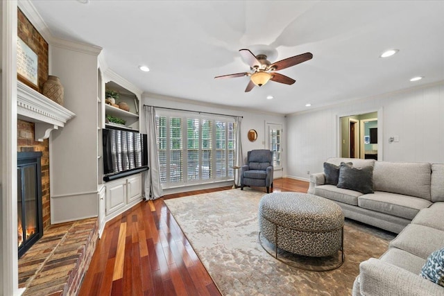living room featuring a fireplace, ornamental molding, ceiling fan, wood finished floors, and recessed lighting