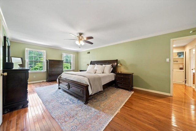 bedroom featuring hardwood / wood-style flooring, baseboards, ornamental molding, and ceiling fan