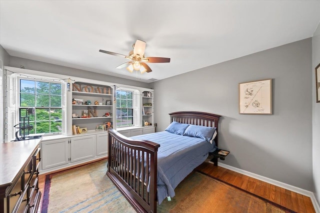 bedroom featuring baseboards, light wood-style floors, and ceiling fan