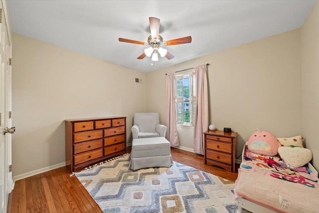 bedroom with wood finished floors, baseboards, and a ceiling fan