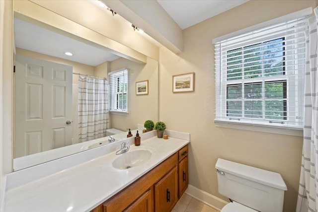 bathroom featuring toilet, baseboards, vanity, and tile patterned floors