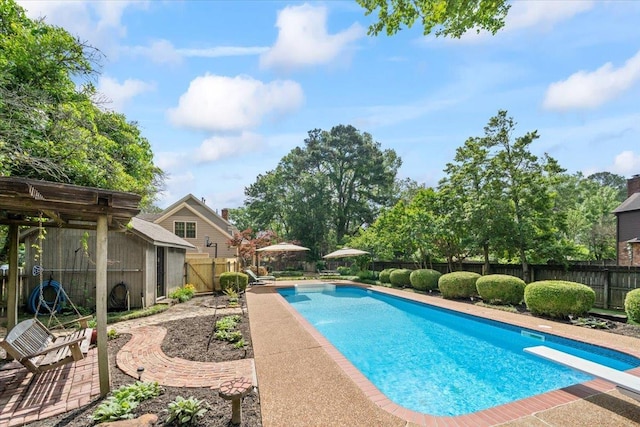 view of swimming pool with a fenced backyard and a diving board
